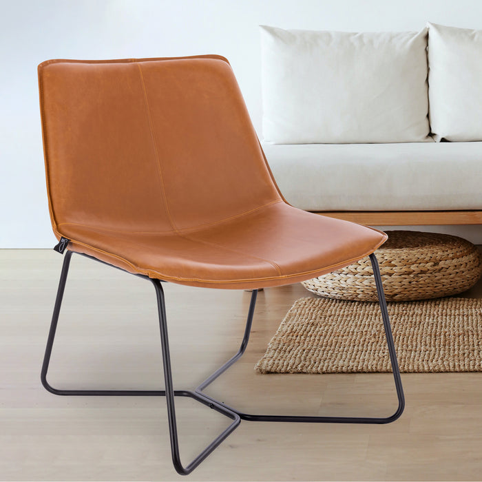 Moderner Stuhl mit cognacbraunem Kunstlederbezug und schwarzem Metallgestell vor einem weißen Sofa und einem Teppich