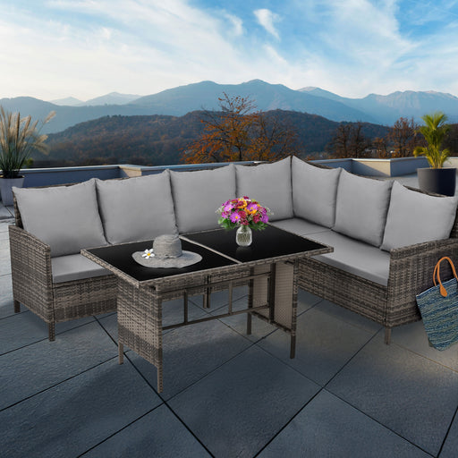 Eckige Gartenlounge mit grauen Polstern und schwarzem Tisch auf Terrasse mit Bergblick, Tisch mit Blumenstrauß und Sonnenhut