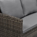 Eckteil eines braunen Polyrattan-Sofas mit grauen Sitz- und Rückenkissen