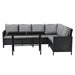 Schwarze Rattan-Ecklounge mit grauen Kissen und schwarzem Tisch