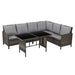 Ecklounge aus braunem Polyrattan mit grauen Sitz- und Rückenkissen und einem rechteckigen Tisch mit schwarzer Glasplatte