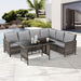 Eckige Gartenlounge aus braunem Rattan mit grauen Polstern und schwarzem Glastisch auf heller Terrasse vor moderner weißer Hausfassade und Palmen
