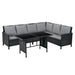 Schwarze Eck-Gartenlounge mit grauen Polsterkissen und schwarzem rechteckigem Tisch mit Glasplatte