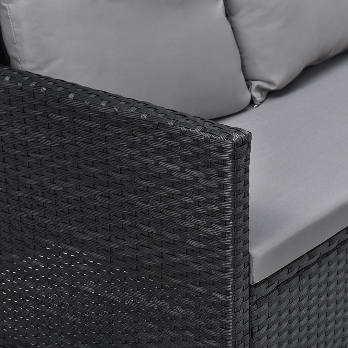 Schwarze, geflochtene Armlehne eines Garten-Sofas mit grauen Sitz- und Rückenkissen
