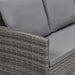 Eckansicht eines grauen Rattan-Gartensofas mit grauen Polsterkissen