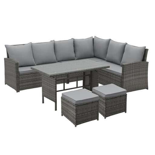 Graues Gartenmöbel-Set aus Polyrattan mit Ecksofa, Tisch mit Glasplatte und zwei Hockern, ideal für Terrasse oder Balkon.