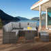 Polyrattan-Lounge-Set mit Tisch und Hockern auf moderner Terrasse mit Panorama-Ausblick auf See und Berge.