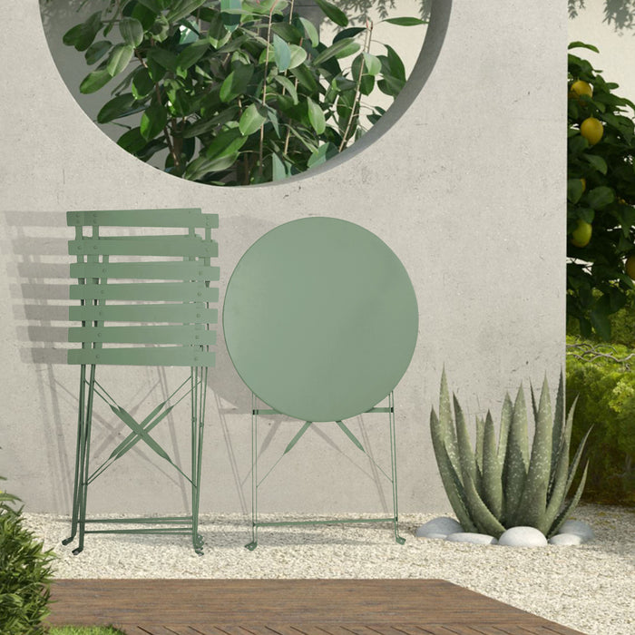 Kleines Metall-Bistro-Set mit rundem Tisch und zwei Klappstühlen in mintgrün steht zusammengeklappt auf einer Terrasse