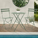 Kleines Metall-Bistro-Set mit rundem Tisch und zwei Klappstühlen in mintgrün steht an einem Pool