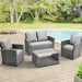 Gartenmöbel-Set aus schwarzem Polyrattan mit zwei Sesseln, einem Sofa und einem Glastisch mit Ablage auf einer Terrasse mit Pool im Hintergrund