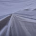 Nahaufnahme einer grauen, glatten Stoffoberfläche mit sichtbarer Naht