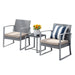 Zweisitzige graue Rattan-Gartenmöbel mit beigen Sitzkissen, kleinem schwarzen Tisch dazwischen mit Blumenvase und zwei Gläsern, ein Stuhl mit blau-weiß gestreiftem Kissen