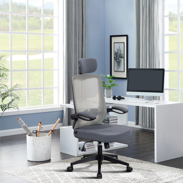 Moderner ergonomischer Bürostuhl mit grauem Netzrücken und Kopfstütze vor weißem Schreibtisch mit Computer in hellem Raum mit großen Fenstern