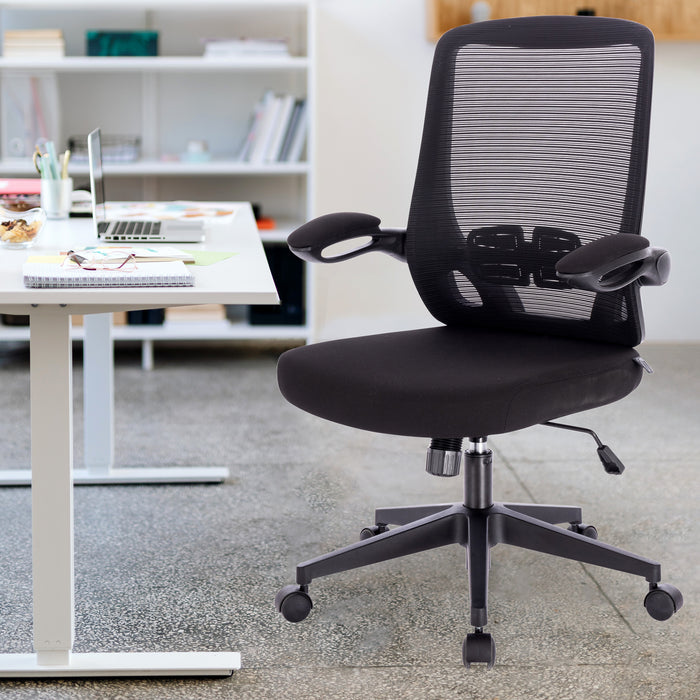 Schwarzer ergonomischer Bürostuhl mit Netzrückenlehne und Armlehnen vor einem weißen Schreibtisch mit Laptop und Notizbuch