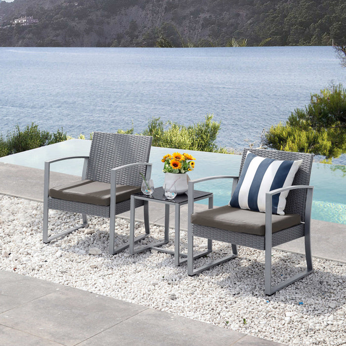 Zwei graue Gartenstühle mit braunen Sitzkissen und ein kleiner Tisch mit Vase und Sonnenblumen am Rand eines Pools mit Blick auf einen See und bewaldete Hügel