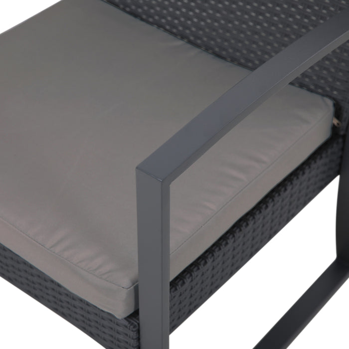 Grau gepolsterter Sitz auf einem schwarzen, geflochtenen Stuhl mit rechteckiger Metallarmlehne