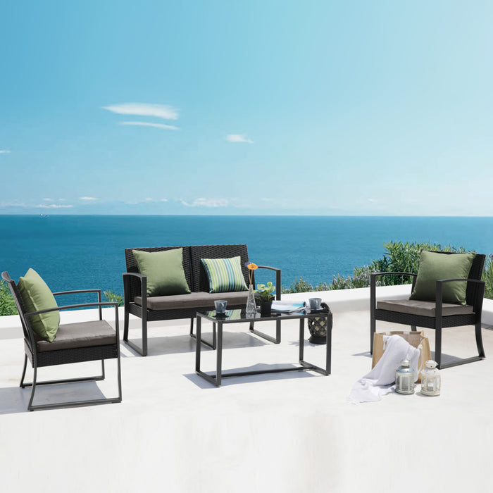 Moderner Sitzbereich mit zwei Sesseln, einem Sofa und einem Glastisch auf weißer Terrasse mit Blick auf das blaue Meer