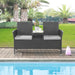 Zweisitzige Gartenbank aus schwarzem Rattan mit zwei grauen Sitzkissen und integriertem Tisch mit Glasplatte in der Mitte steht an einem Pool