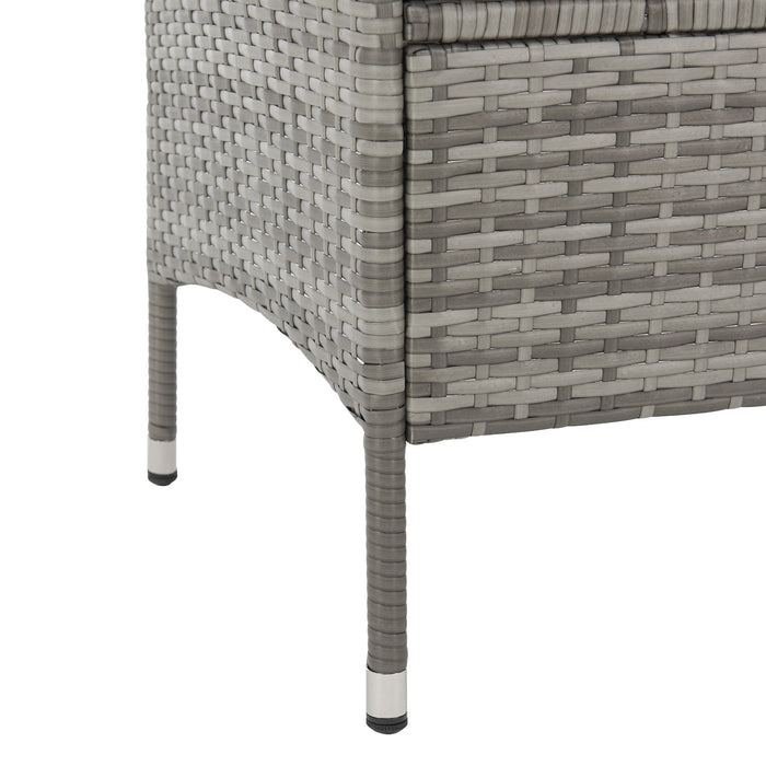 Bein einer grauen, geflochtenen Gartenbank aus Polyrattan mit Metallkappen am Fuß