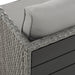 Eckdetail des grauen Polyrattan-Gartensofas mit grauem Kissen und schwarzer Tischplatte an der Rückseite