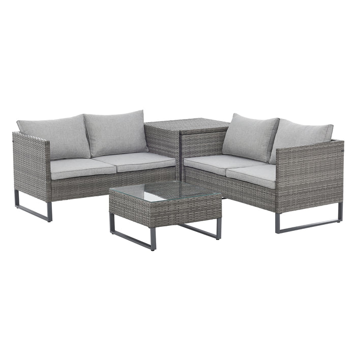 Graue Polyrattan Gartenlounge mit zwei Bänken über Eck gestellt mit Kissenbox dazwischen und Tisch
