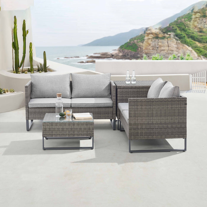 Graue Polyrattan Gartenlounge mit Kissenbox auf einer sonnigen Terrasse