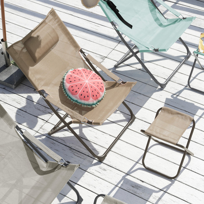 Sandfarbener Klappstuhl mit rundem Kissen in Form einer Wassermelone auf weißem Holzdeck, umgeben von weiteren Klappstühlen in Beige und Hellblau