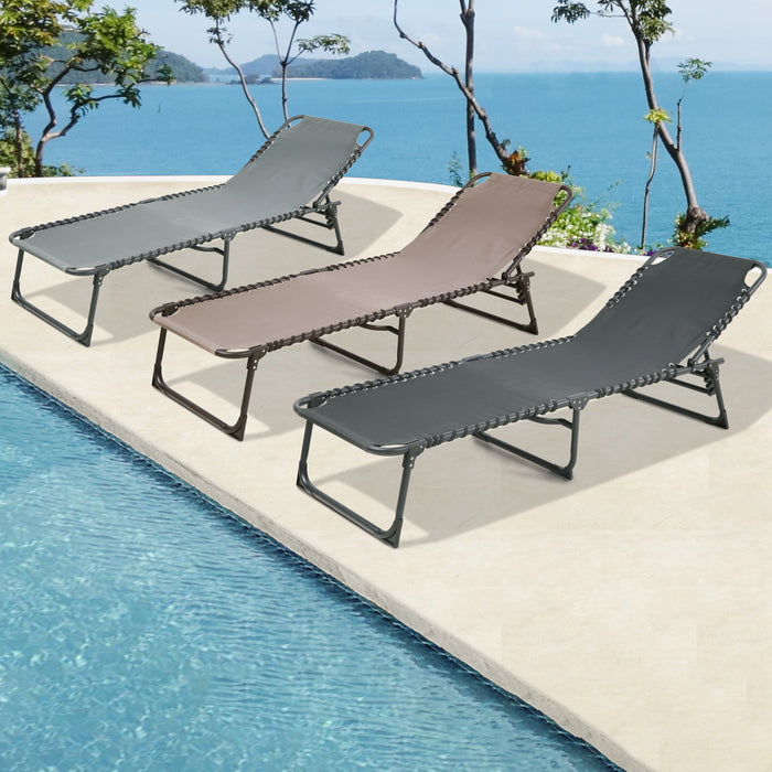 Drei Sonnenliegen in den Farben hellgrau, beige und dunkelgrau stehen an einem sonnigen Pool