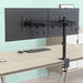 Schwarze doppelte Monitorhalterung aus Metall an einem hellen Holzschreibtisch mit Tastatur und Maus