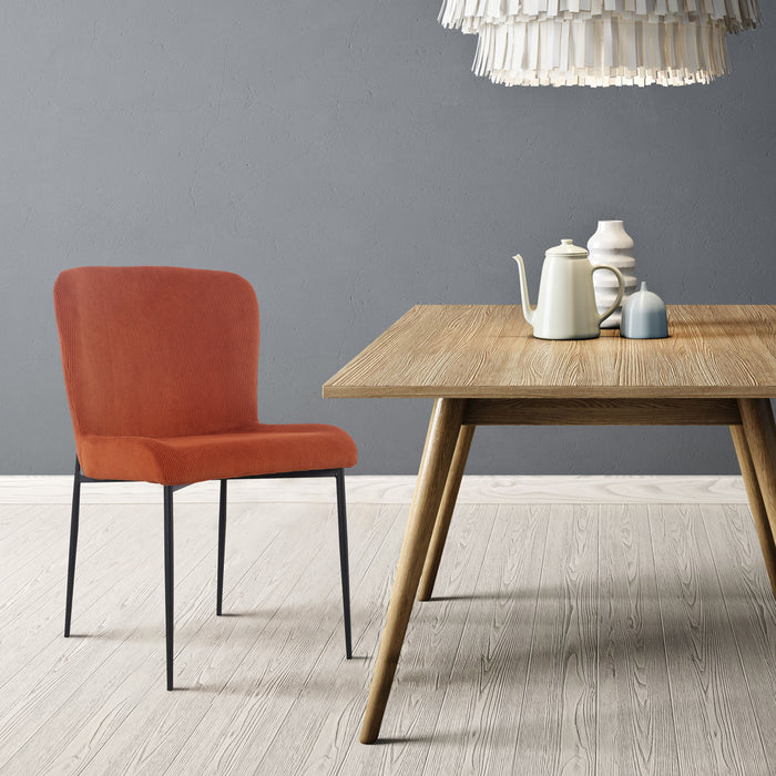 Orangener SVITA Freddie Esszimmerstuhl mit modernem Design neben einem Holztisch mit Teekanne und Vasen vor grauer Wand