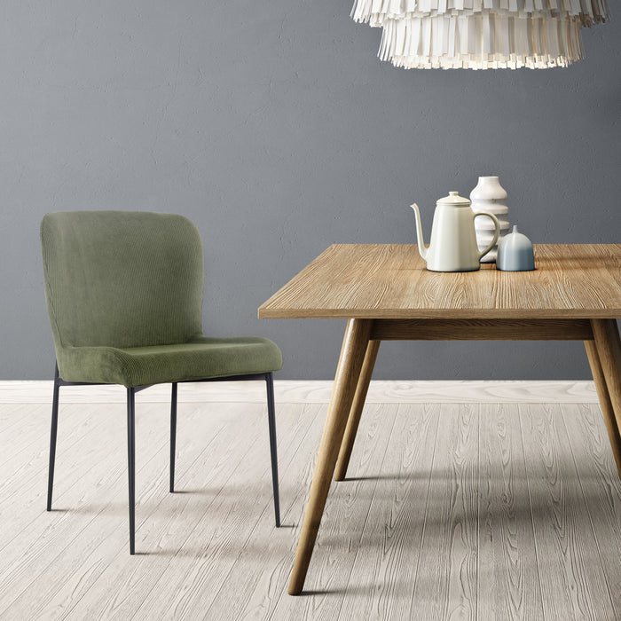 Grüner SVITA Freddie Esszimmerstuhl mit modernem Design neben einem Holztisch mit Teekanne und Vasen vor grauer Wand
