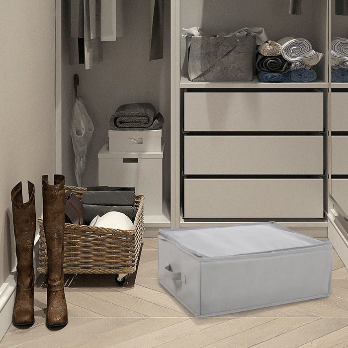 Graue Aufbewahrungsbox auf dem Boden vor einem begehbarer Kleiderschrank mit weißen Schubladen, gefalteten Handtüchern und braunen Stiefeln