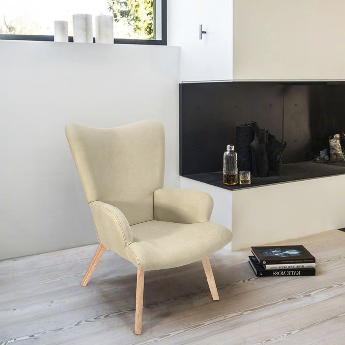 Beiger Sessel mit Holzbeinen neben modernem Kamin und zwei Büchern auf dem Boden in hellem Raum