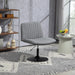 Grauer Lounge-Sessel mit runder Metallbasis auf grauem Teppich mit geometrischem Muster in modernem Wohnzimmer