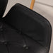 Nahaufnahme Schwarzer Sitz mit Knopfheftung und Armlehne