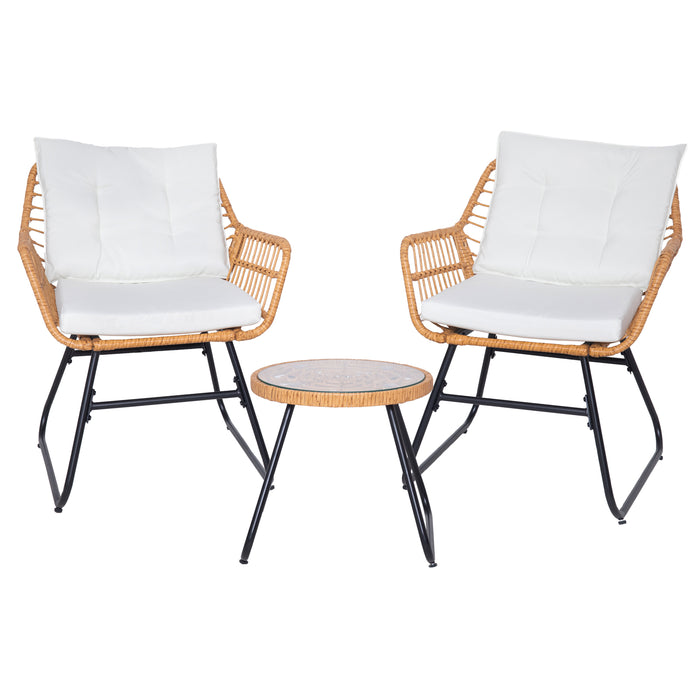 Zwei Rattanstühle mit weißen Kissen und ein kleiner runder Tisch mit Glasplatte, alle mit schwarzen Metallbeinen