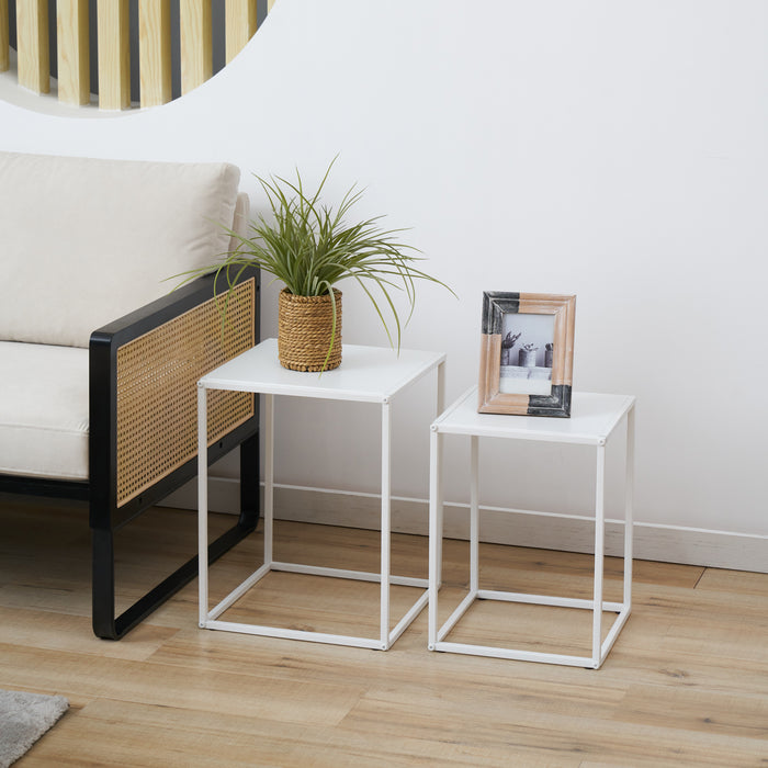 Zweier-Set weiße Couchtische aus Metall mit quadratischer Form, dekoriert mit Pflanze und Bilderrahmen, neben einem beige-schwarzen Sessel