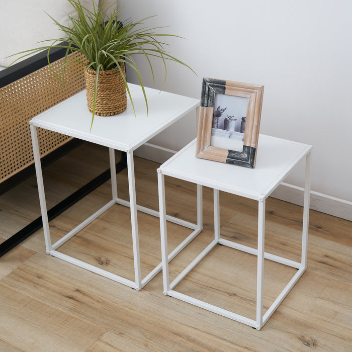 Nahaufnahme von zweier-Set weiße Couchtische aus Metall mit quadratischer Form, dekoriert mit Pflanze und Bilderrahmen