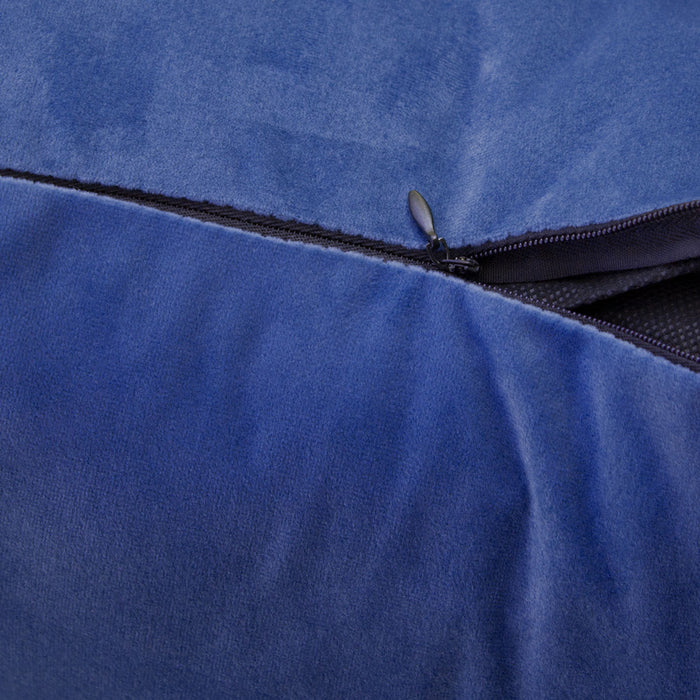 Nahaufnahme eines geöffneten Reißverschlusses an einem blauen Samtkissen